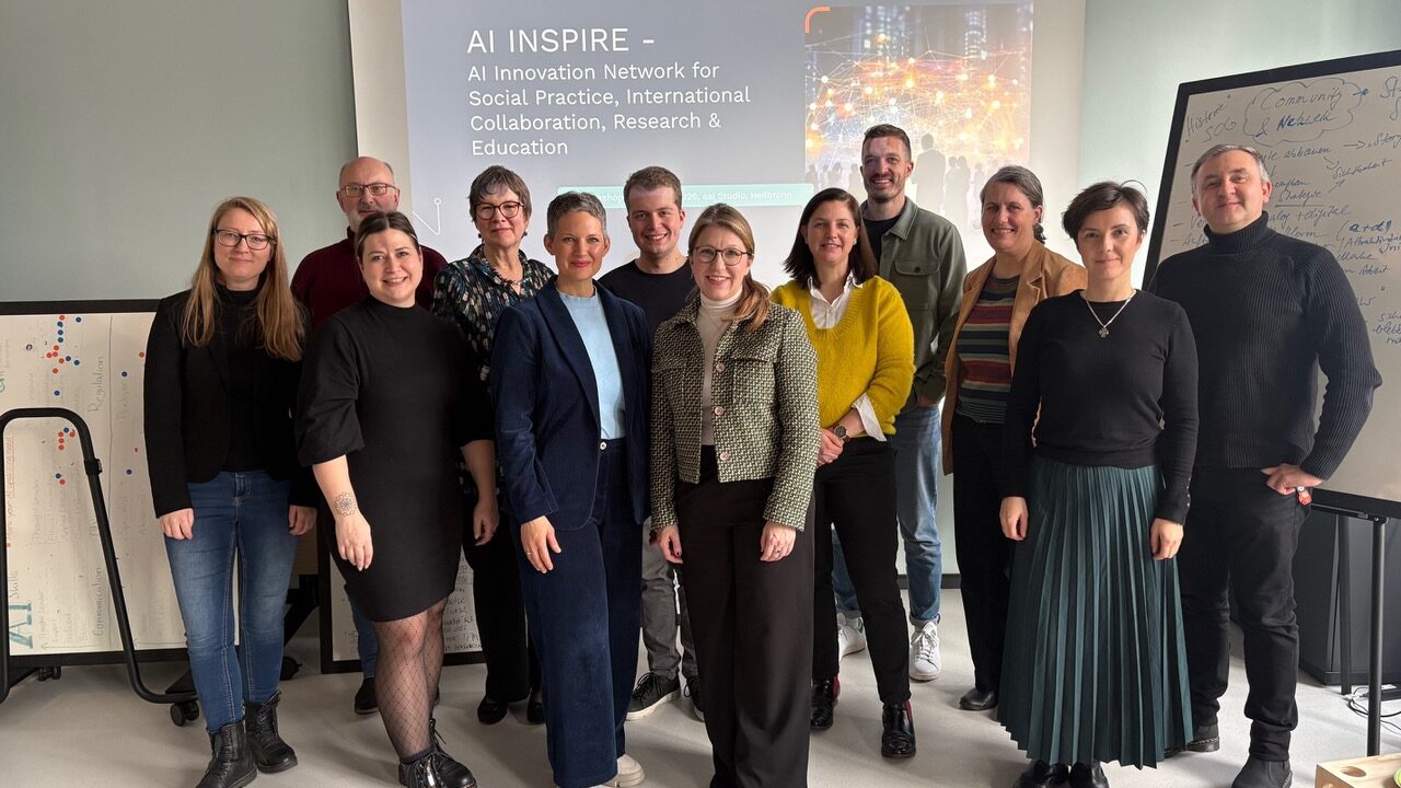 Gruppenfoto von Workshop-Teilnehmenden vor einer Präsentation zu AI INSPIRE.